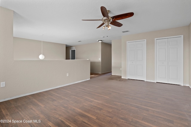 unfurnished living room featuring dark hardwood / wood-style floors and ceiling fan