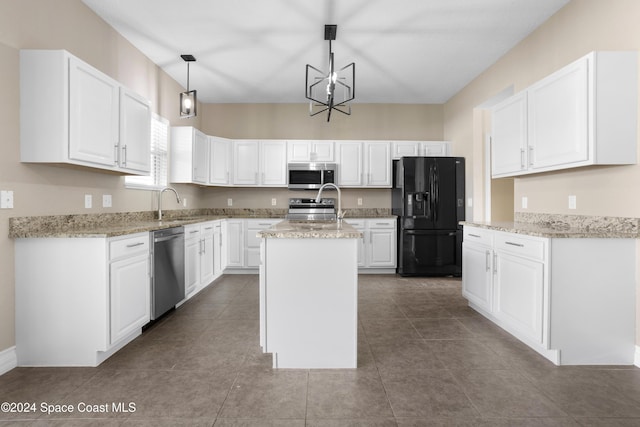 kitchen featuring a center island with sink, white cabinets, hanging light fixtures, and appliances with stainless steel finishes