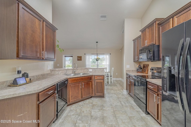 kitchen featuring visible vents, a peninsula, a sink, hanging light fixtures, and black appliances