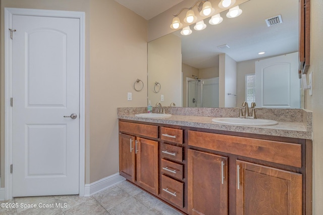 full bathroom featuring double vanity, visible vents, a shower stall, and a sink