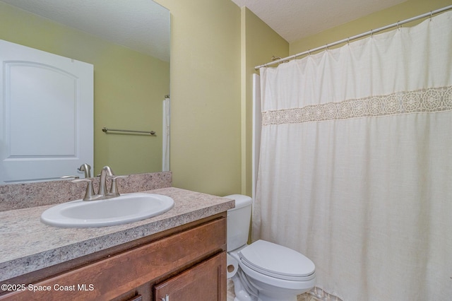 bathroom with vanity, toilet, and a textured ceiling