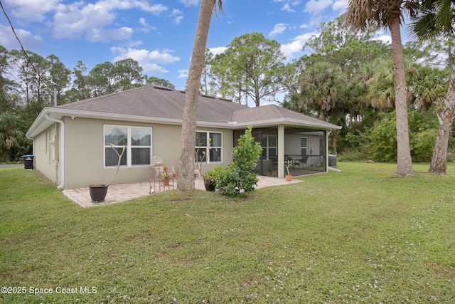 back of house with stucco siding, a yard, roof with shingles, a sunroom, and a patio area