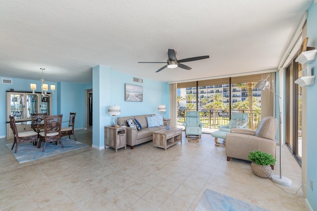 living room with ceiling fan with notable chandelier, floor to ceiling windows, and a textured ceiling