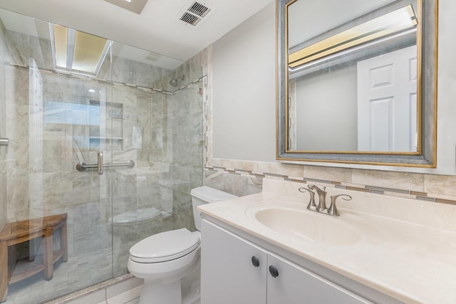 bathroom with an enclosed shower, vanity, toilet, and tile walls