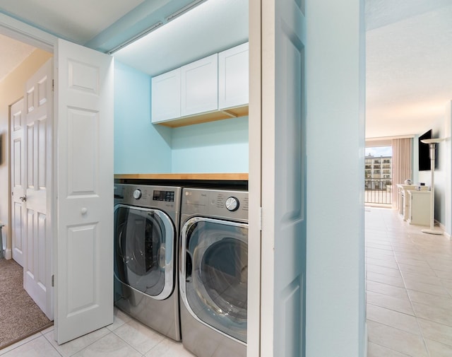 laundry area featuring light tile patterned floors and washing machine and clothes dryer