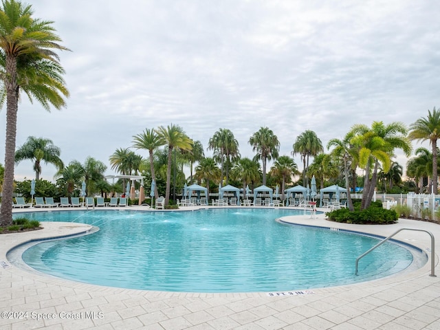 view of swimming pool with pool water feature and a patio area