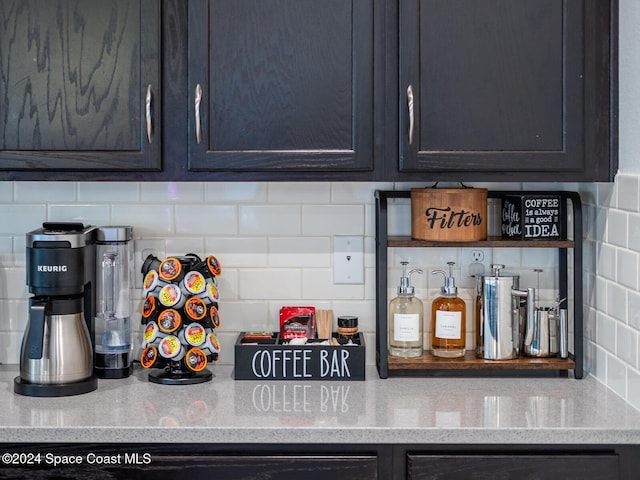 kitchen featuring decorative backsplash and light stone counters