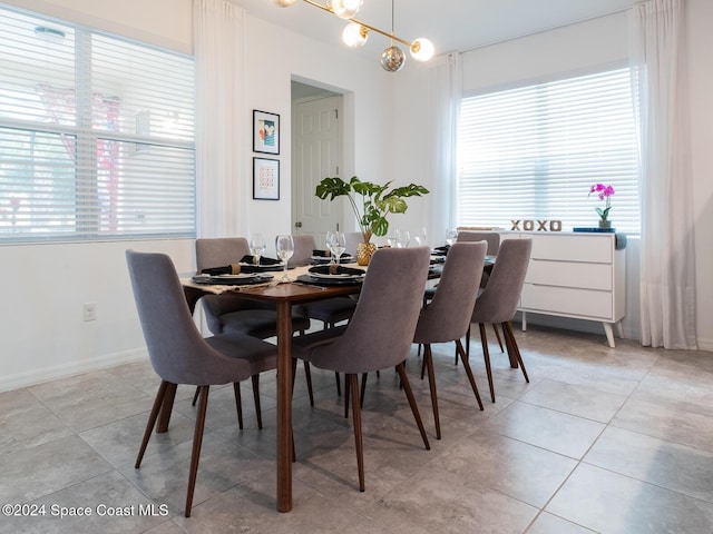 tiled dining room with an inviting chandelier