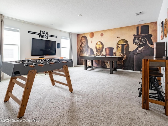 game room featuring carpet floors and a textured ceiling