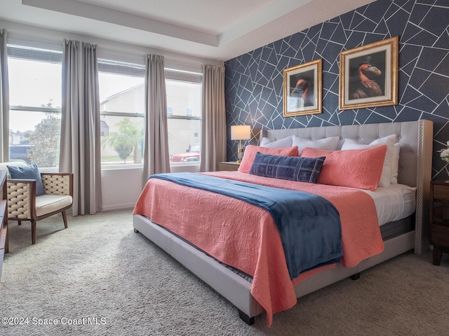 carpeted bedroom with a tray ceiling