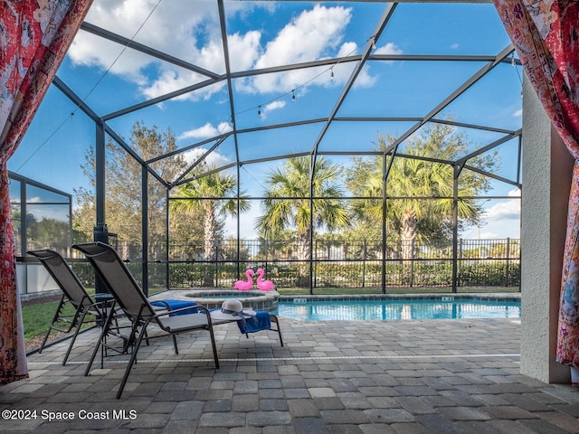 view of pool featuring a lanai, a patio area, and an in ground hot tub