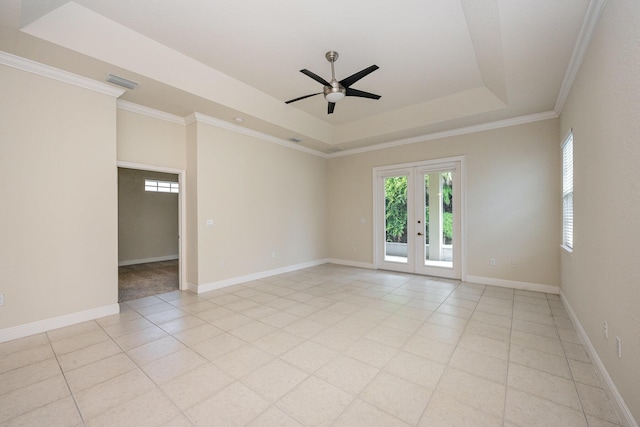 unfurnished room featuring a tray ceiling, ceiling fan, french doors, and ornamental molding