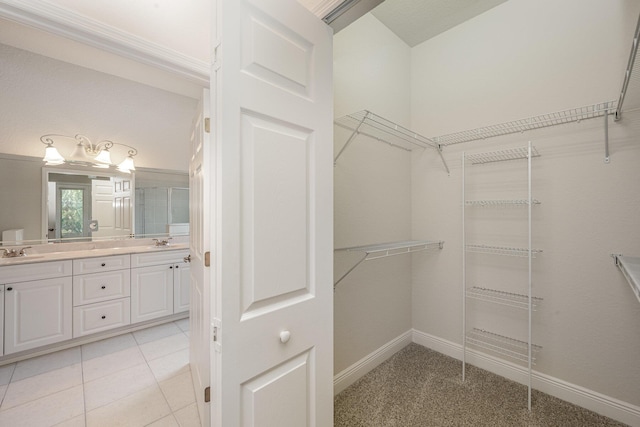 walk in closet with light tile patterned flooring and sink