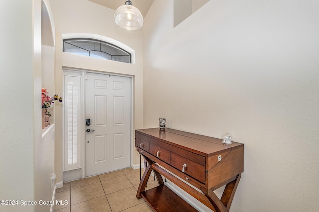 foyer entrance featuring light tile patterned floors and a towering ceiling