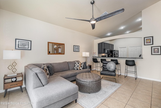 living room with ceiling fan, light tile patterned flooring, and lofted ceiling