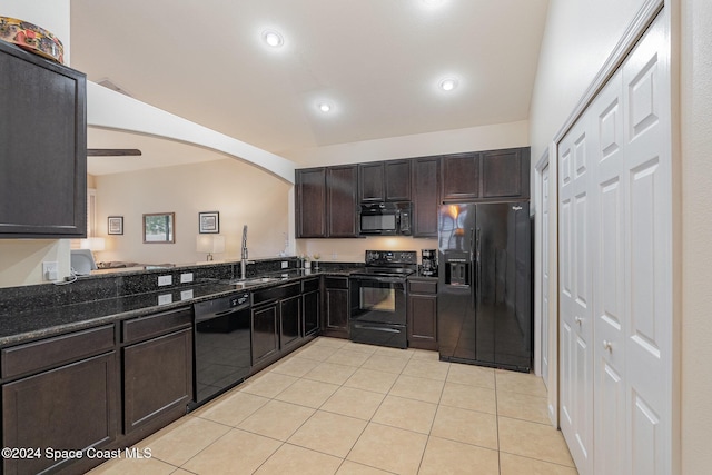 kitchen with dark brown cabinetry, sink, lofted ceiling, light tile patterned flooring, and black appliances