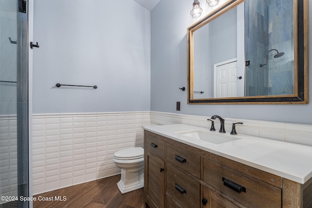 bathroom featuring an enclosed shower, vanity, toilet, and tile walls