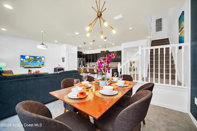 tiled dining room with an inviting chandelier