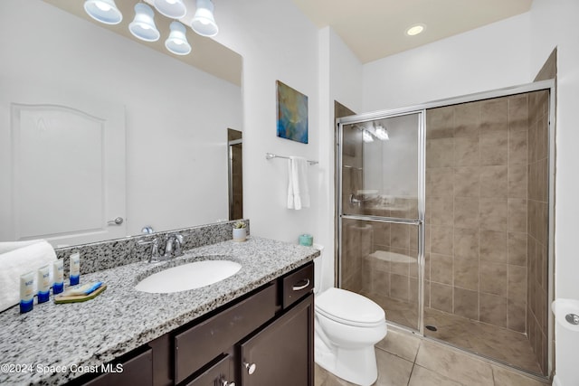 bathroom with tile patterned flooring, vanity, toilet, and a shower with door