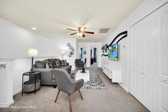 carpeted living room with ceiling fan