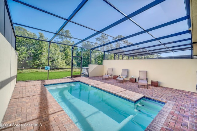 view of swimming pool with a lanai, a patio area, and a lawn