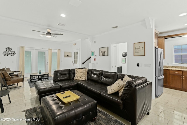 living room with light tile patterned floors, ceiling fan, and crown molding