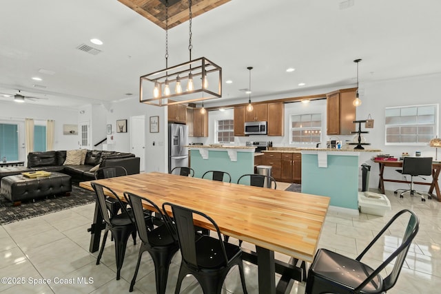 dining area featuring light tile patterned floors, ceiling fan, and crown molding