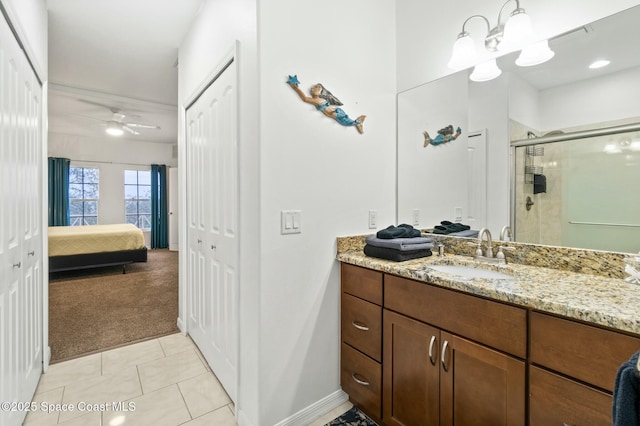 bathroom featuring tile patterned flooring, ceiling fan, a shower with door, and vanity