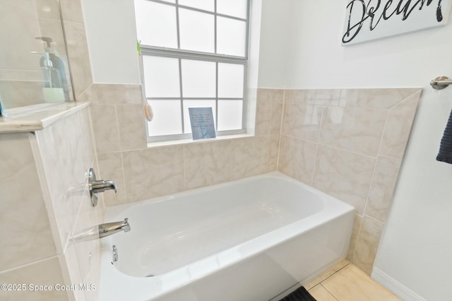 bathroom with tile patterned floors and a tub to relax in