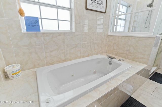 bathroom featuring tile patterned flooring, tile walls, and tiled bath