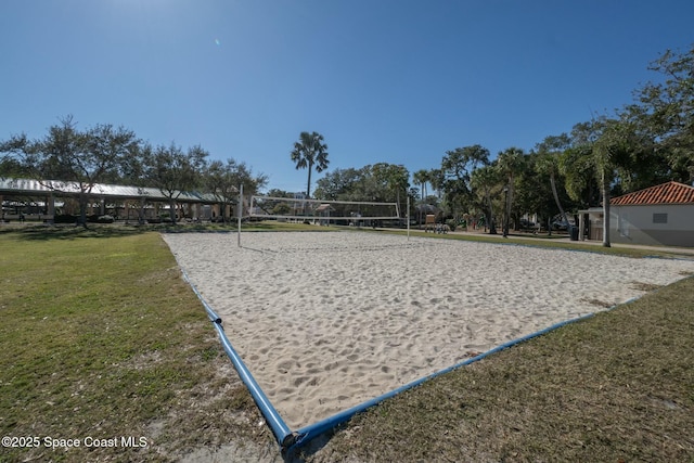 view of property's community with a lawn and volleyball court