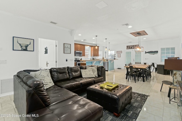 living room featuring crown molding and light tile patterned flooring