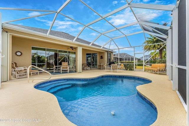 view of swimming pool featuring a patio area, ceiling fan, and glass enclosure