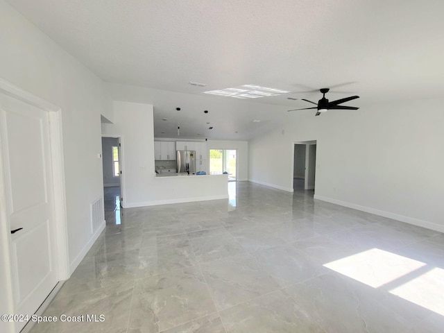 unfurnished living room with lofted ceiling, ceiling fan, and a textured ceiling