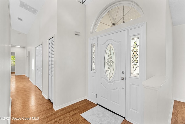 entryway featuring high vaulted ceiling and light hardwood / wood-style floors