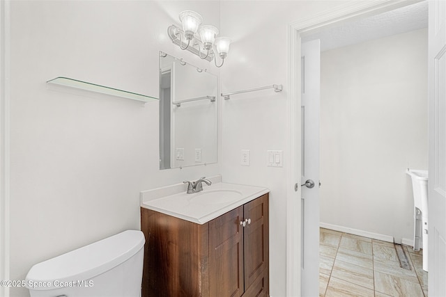 bathroom with toilet, vanity, and tile patterned floors