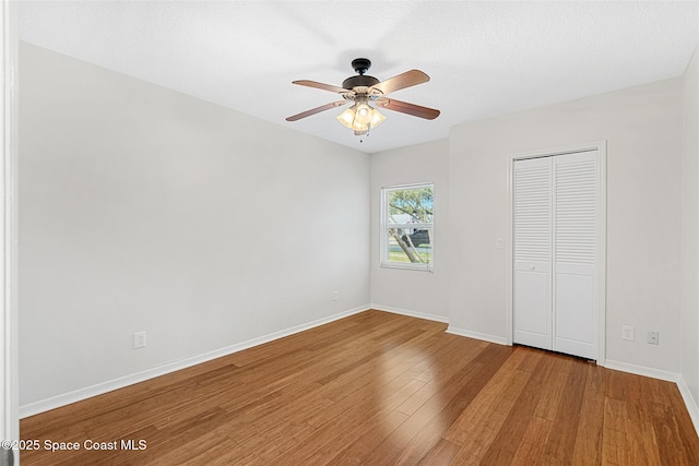 unfurnished bedroom featuring a closet, ceiling fan, and hardwood / wood-style flooring