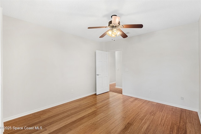 empty room with ceiling fan and light hardwood / wood-style floors