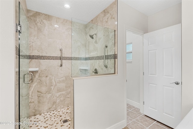 bathroom with an enclosed shower and tile patterned floors