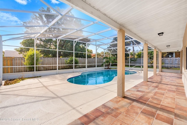 view of pool with glass enclosure and a patio