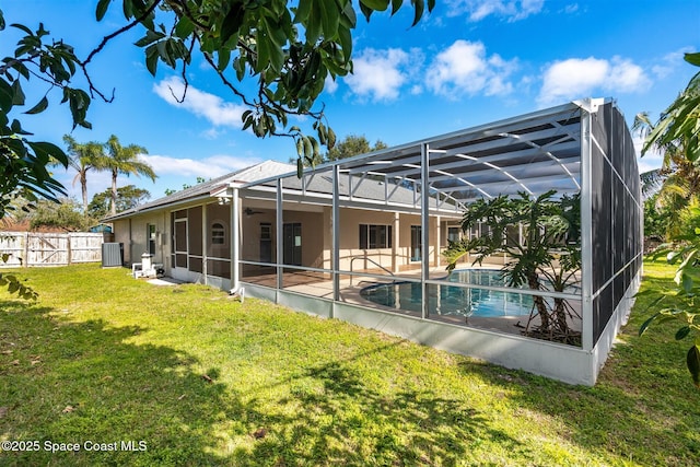 rear view of property featuring a lawn, a patio, glass enclosure, cooling unit, and a fenced in pool