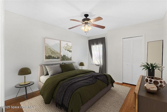 bedroom with ceiling fan, a closet, and hardwood / wood-style flooring