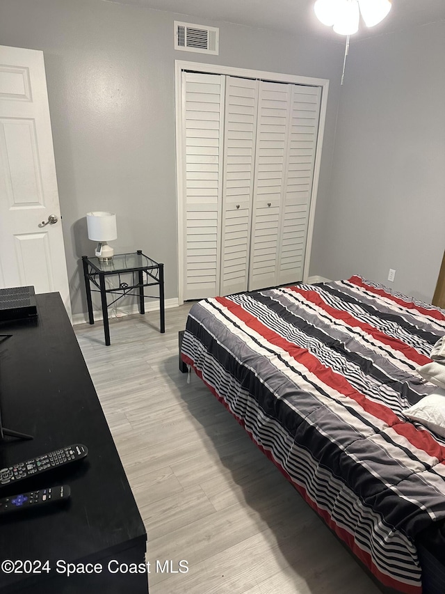 bedroom with light wood-type flooring and a closet