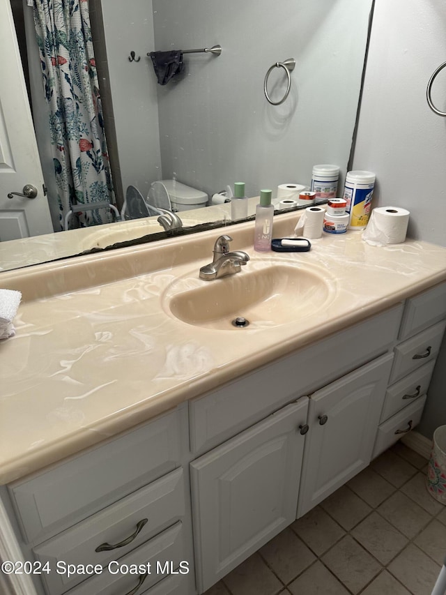 bathroom with tile patterned flooring, vanity, and toilet