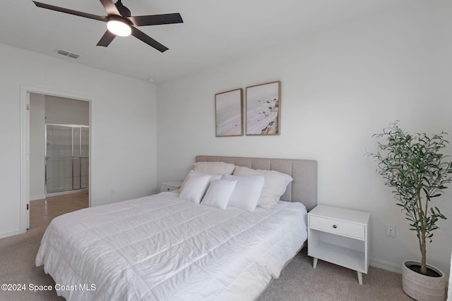 bedroom with connected bathroom, ceiling fan, and light carpet