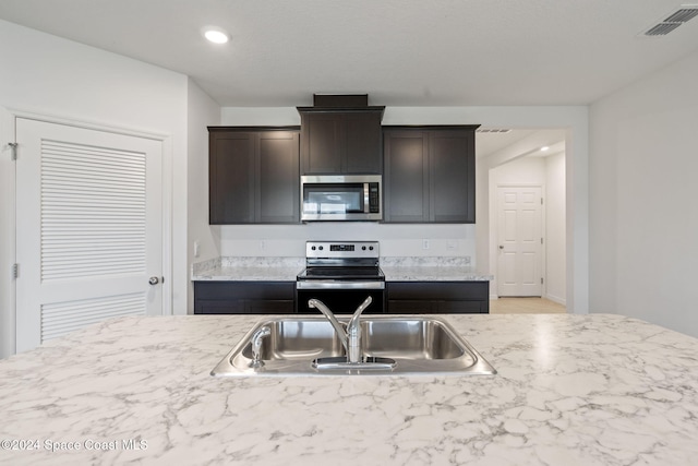 kitchen featuring appliances with stainless steel finishes, dark brown cabinetry, and sink