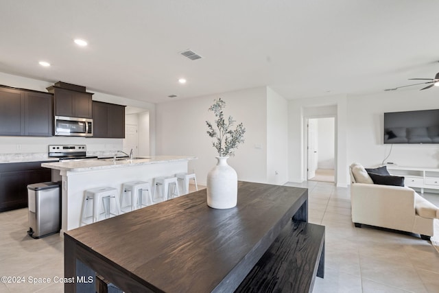 dining space with ceiling fan and light tile patterned floors