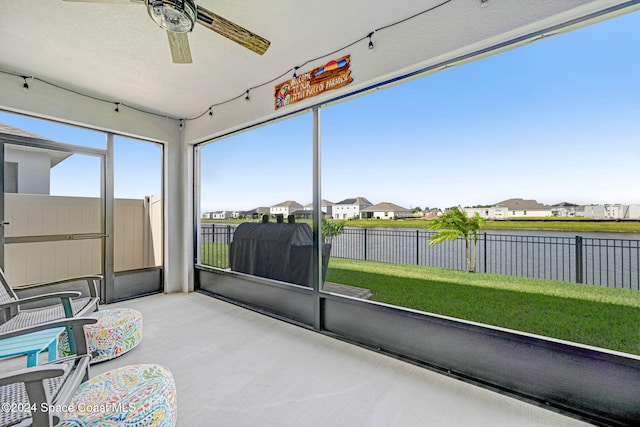 unfurnished sunroom featuring ceiling fan