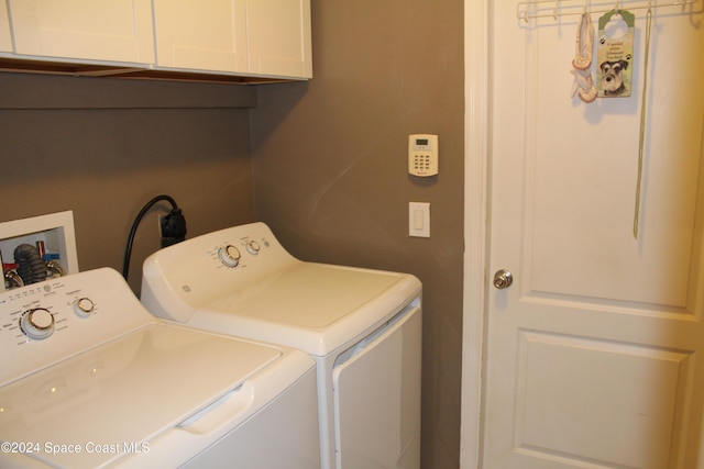 laundry room with washer and dryer and cabinets