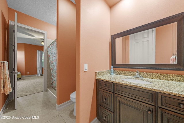 bathroom with a textured ceiling, vanity, tile patterned flooring, toilet, and curtained shower